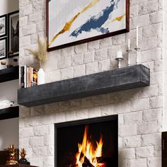 a living room with a fire place in the center and pictures on the wall above it