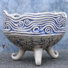 a blue and white ceramic bowl sitting on top of a table next to a wall