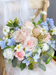 a bouquet of flowers sitting on top of a wooden chair