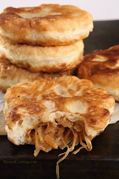 three pancakes stacked on top of each other with cheese and onions in the middle,