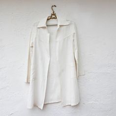 Vintage 1920's white linen duster has a wide collar, front patch pockets and long sleeves. This is a very lovely, light weight jacket. Dusters were worn in the roaring 20's and before, when people took motor trips in open automobiles on dirt roads. The duster kept their clothes clean. Celebrating the 1920's! 20% off everything from the 1920's for 20 days, until January 18th. Fits like a current 4 or smaller Measurements with room for comfort Bust up to 37 inches Waist up to 39 inches Hips up to White Linen Outerwear With Pockets, White Linen Outerwear With Lapel Collar, White Cotton Outerwear For Daywear, White Collared Outerwear For Daywear, Fitted White Linen Outerwear, White Fitted Linen Outerwear, White Spring Outerwear With Spread Collar, White Lapel Collar Outerwear For Daywear, White Lapel Collar Outerwear For Daytime