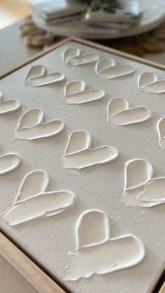 there are many white hearts on the cookie sheet