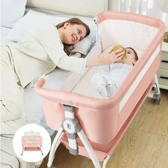 a woman laying in bed next to a baby sleeping on top of a pink crib