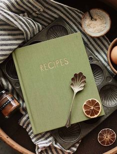 an open recipe book sitting on top of a table next to other dishes and utensils