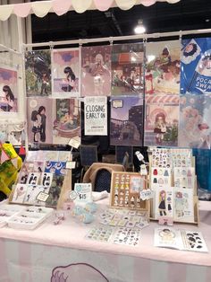 a table with pictures and cards on it at a fair or show, in front of a tent