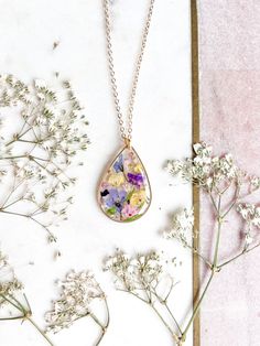 A pressed and preserved wild flowers necklace within a teardrop frame.  Available in both gold or silver. On a choice of necklace lengths.   Complimentary gift wrap. Dainty Pressed Flowers Pendant Necklace, Dainty Flower Necklace With Pressed Flowers, Gold Jewelry With Floral Print For Gift, Gold Dainty Flower Necklace With Pressed Flowers, Dainty Gold Flower Necklace With Pressed Flowers, Gold Teardrop Jewelry With Pressed Flowers, Gold Teardrop Jewelry With Birth Flower Detail, Gold Teardrop Jewelry With Birth Flower, Flowers Jewellery