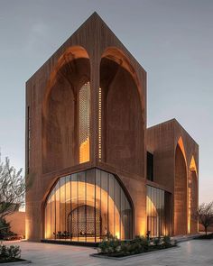 an architecturally designed building lit up at night with lights on the outside and inside