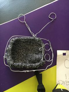 a black purse sitting on top of a purple and yellow wall