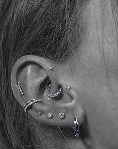 a close up of a person with ear piercings on their ears and behind the ear