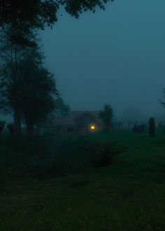 a house in the fog at night with a light shining on it's face