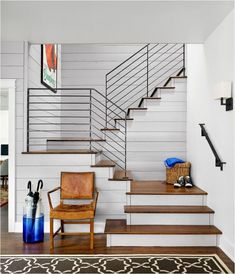 a living room filled with furniture next to a stair case