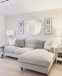 a living room filled with furniture and a mirror on the wall above it's headboard