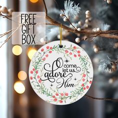 a christmas ornament hanging from a tree with lights in the background and free gift box