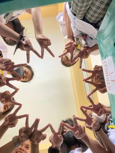 a group of people holding their hands up in the shape of a circle with fingers