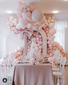 the table is set with white and pink balloons