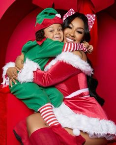 a woman holding a child dressed as santa clause