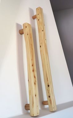 two pieces of wood sitting on top of a white counter next to each other in front of a wall