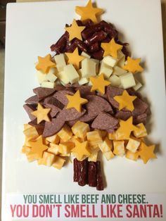 a christmas tree made out of cheese and crackers on a cutting board with the caption you smell like beef and cheese you don't smell like santa