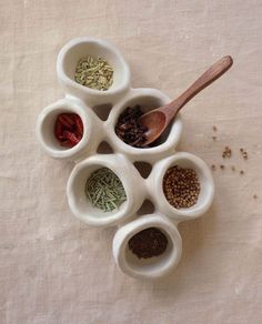 five small bowls filled with different types of spices