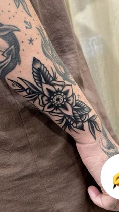 a person with a tattoo on their arm holding a banana