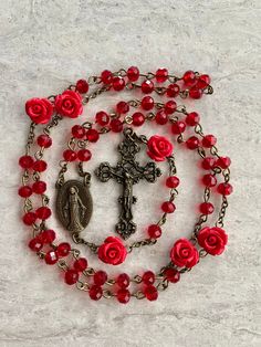 A beautiful handcrafted Catholic five decade tradition style chains prayer rosary. It's a great and thoughtful gift for someone special.  Made with red 6mm crystal beads for the decades, and optional red rose accent 10mm beads for the Our Father's. If without roses is desired the rose beads will be replaced with the red crystal.  You have the option of Silver or Bronze for the metal Crucifix and Virgin Mary medallion. Each rosary is handmade in Florida with love.  Customized rosaries are availab Handmade Red Rosary For Jewelry Making, Spiritual Rosary As Valentine's Day Gift, Red Spiritual Rosary As Gift, Handmade Red Rosary With Cross, Handmade Red Cross Rosary, Handmade Red Rosary, Red Crucifix Rosary As Gift, Handmade Red Crucifix Jewelry, Spiritual Red Crucifix Rosary