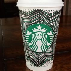 a starbucks cup sitting on top of a wooden table