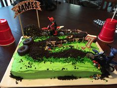 a birthday cake with dirt bike and rider on the top is ready to be eaten