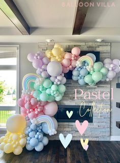 pastel balloons are arranged in the shape of rainbows and hearts on a wall