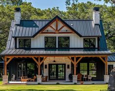 a large house with a metal roof in the woods