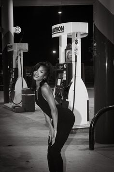 a woman standing in front of a gas pump