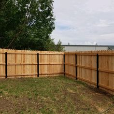 a wooden fence in the middle of a yard