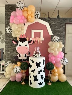 a cow themed birthday party with balloons and decorations