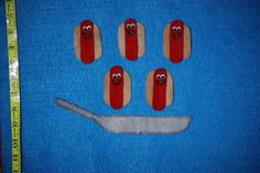 five hotdogs with faces on them and a measuring tape to the side that has been cut out