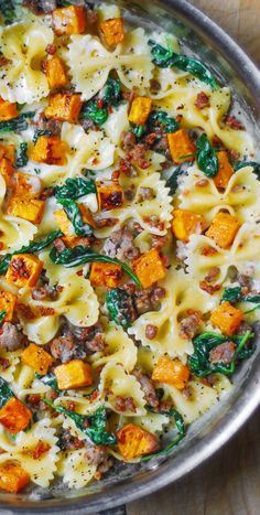 a pan filled with pasta and spinach covered in cheese