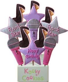 a birthday cake topper with microphones and stars on it's stand that says rock star happy birthday