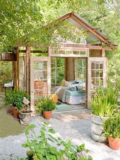 an image of a small garden shed with lots of plants and flowers in the yard