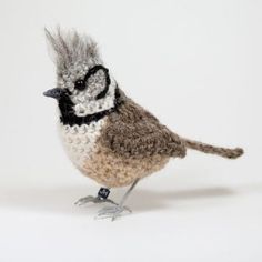 a small stuffed bird sitting on top of a white table