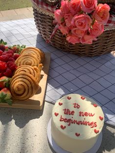 a table topped with a cake next to a basket filled with strawberries and pastries