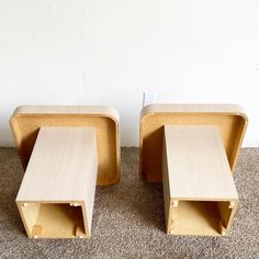 two wooden tables sitting next to each other on carpeted floor with white wall in background