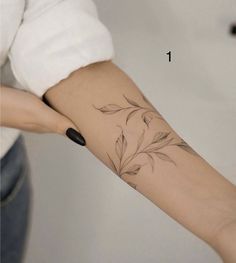 a woman's arm with a flower tattoo on the left side of her arm