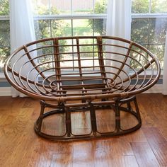 a wooden chair sitting in front of a window on top of a hard wood floor