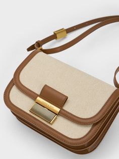 This product is made with at least 20% sustainable materials by weight. CHARLES & KEITH uses recycled, degradable, organic, and water-based materials in our eco-conscious collection. From the match-all canvas finish to the brown trim, this neutral-toned canvas version of our beloved Charlot crossbody bag is set to join the ranks of covetable wardrobe staples you'll want to to use on repeat. Featuring a classic boxy silhouette with chic curved corners, this bag's minimalist design will make matching it with outfits a breeze. Opening up into a spacious interior for all your daily essentials, this bag is as functional as it is stylish. Hermes 2024, Charles And Keith Bags, Handbag Ideas, Brown Crossbody Bag, Fancy Bags, Canvas Crossbody Bag, Bags Shop, Charles Keith, Pretty Bags