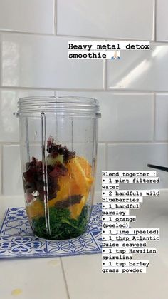 a blender filled with fruit and vegetables on top of a white tiled countertop