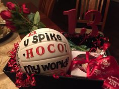 a volleyball in a gift box with the number thirteen on it and some roses around it