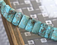 a close up of a bracelet made out of turquoise stones