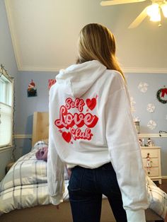 "Look super trendy and spread a self love message with this Valentine's Day hooded sweatshirt! Featuring a \"Self Love Club\" graphic on the back and a heart and arrow graphic on the front, this piece is perfect to finish off your trendy, oversized look! Get matching sweatshirts with your friends and look super cute for galentines day! Makes a great gift for a friend, or for yourself! Please note: This item is PRINTED, not embroidered. Printed on a soft, cotton-poly blend Gildan sweatshirt. SIZI White Hoodie With Lettering In Relaxed Fit, White Long Sleeve Hoodie With Lettering, White Trendy Hoodie With Text Print, Trendy White Hoodie With Text Print, Trendy White Slogan Hoodie, Trendy White Hoodie With Slogan, Self Love Hoodie, Arrow Graphic, Arrows Graphic