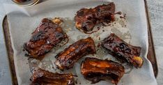 barbecue ribs on wax paper with sauce and ketchup next to it, ready to be eaten