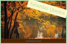 a woman standing in front of a lake surrounded by trees with autumn leaves on it