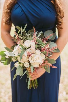 a woman in a blue dress holding a bouquet