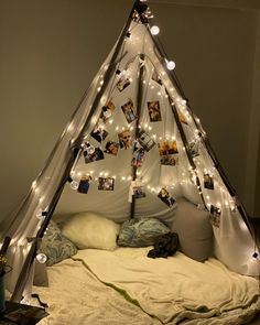 a teepee with lights and pictures hanging from it